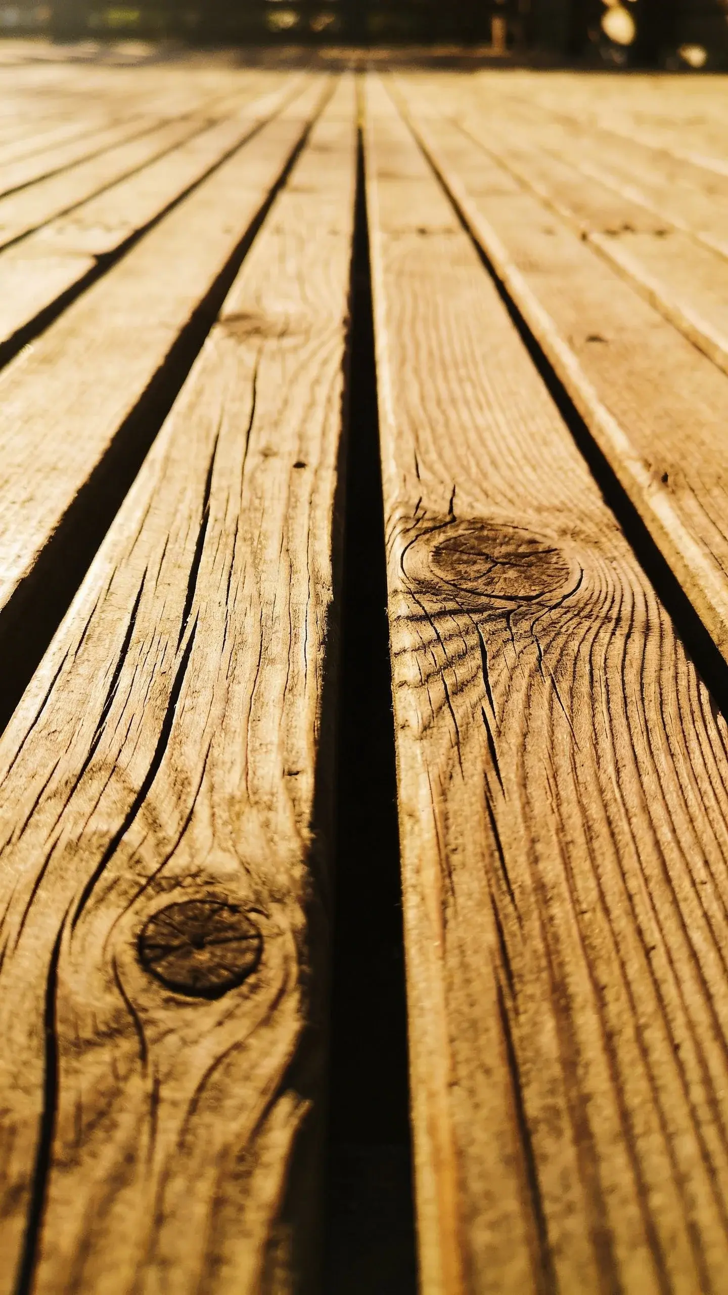 closeup of wooden deck texture with visible grain and sunlit slats