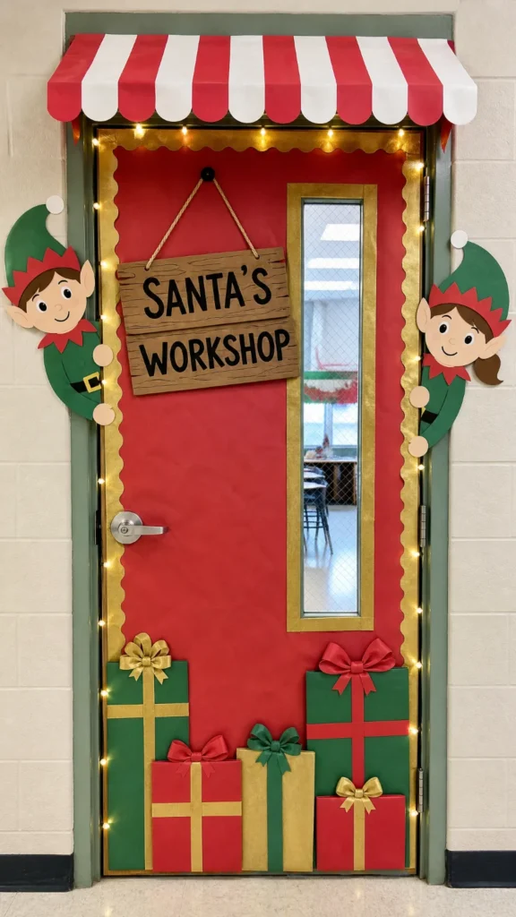 Santa's Workshop classroom door with a red and white striped awning, paper elves peeking from the frame and stacked paper gifts, a Christmas door decorating contest idea