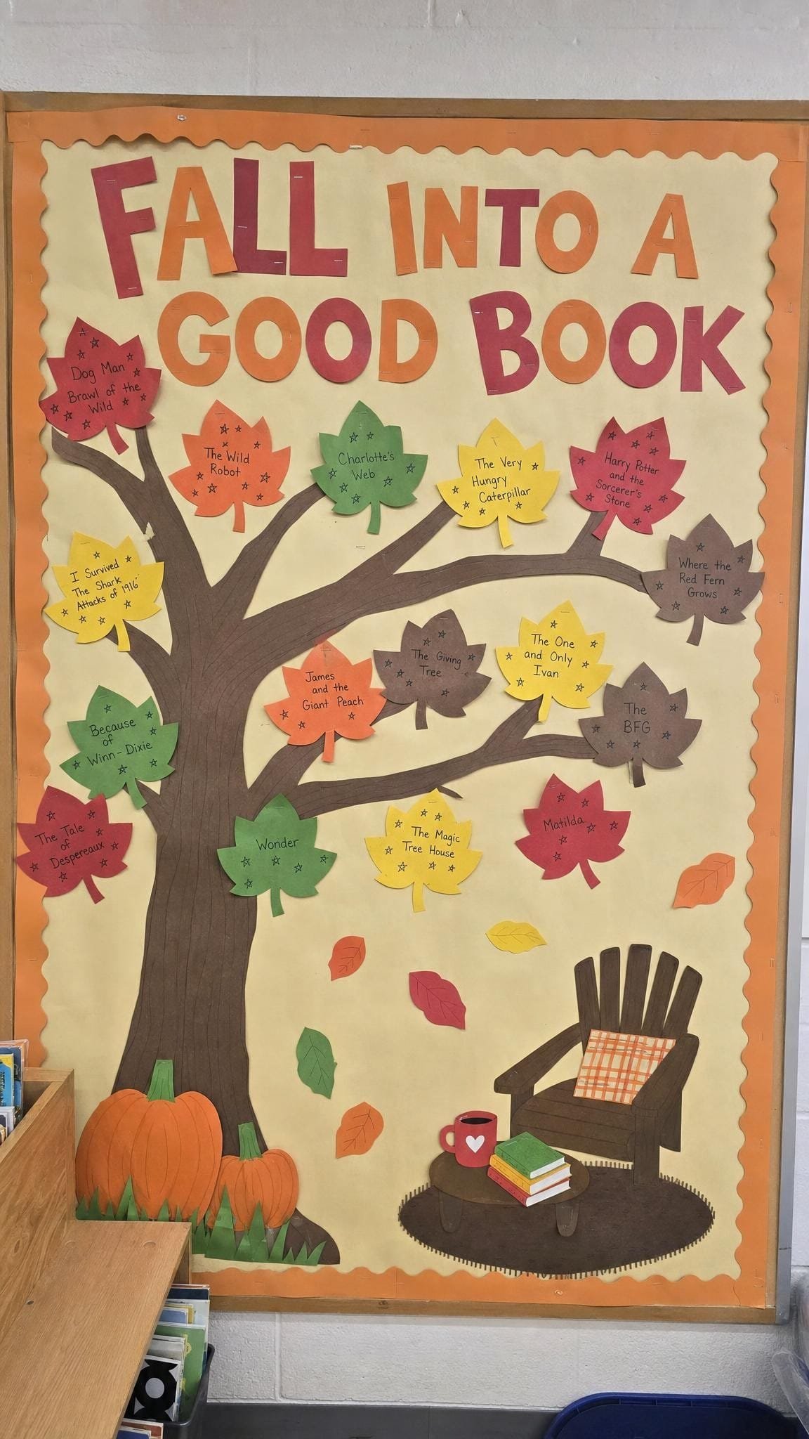 Reading bulletin board with a paper tree and leaves showing book titles and star ratings