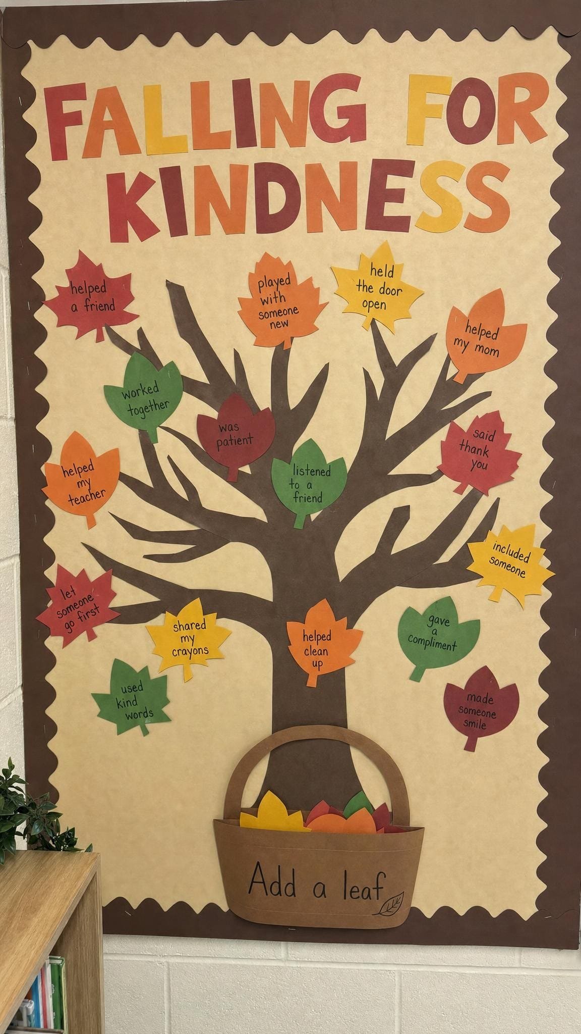 Kindness tree bulletin board with leaves describing kind acts