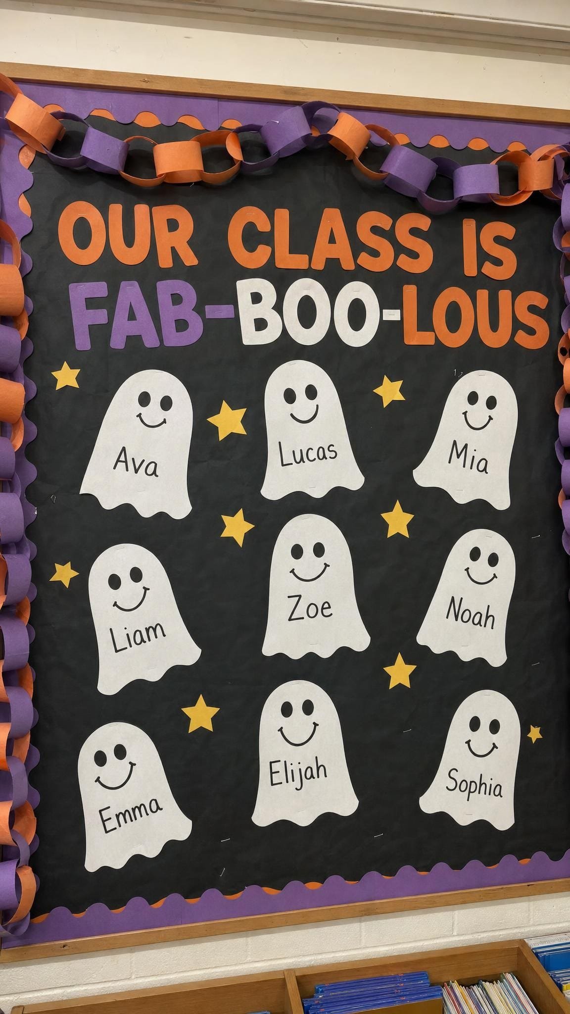 Black bulletin board with friendly paper ghosts labelled with children's names