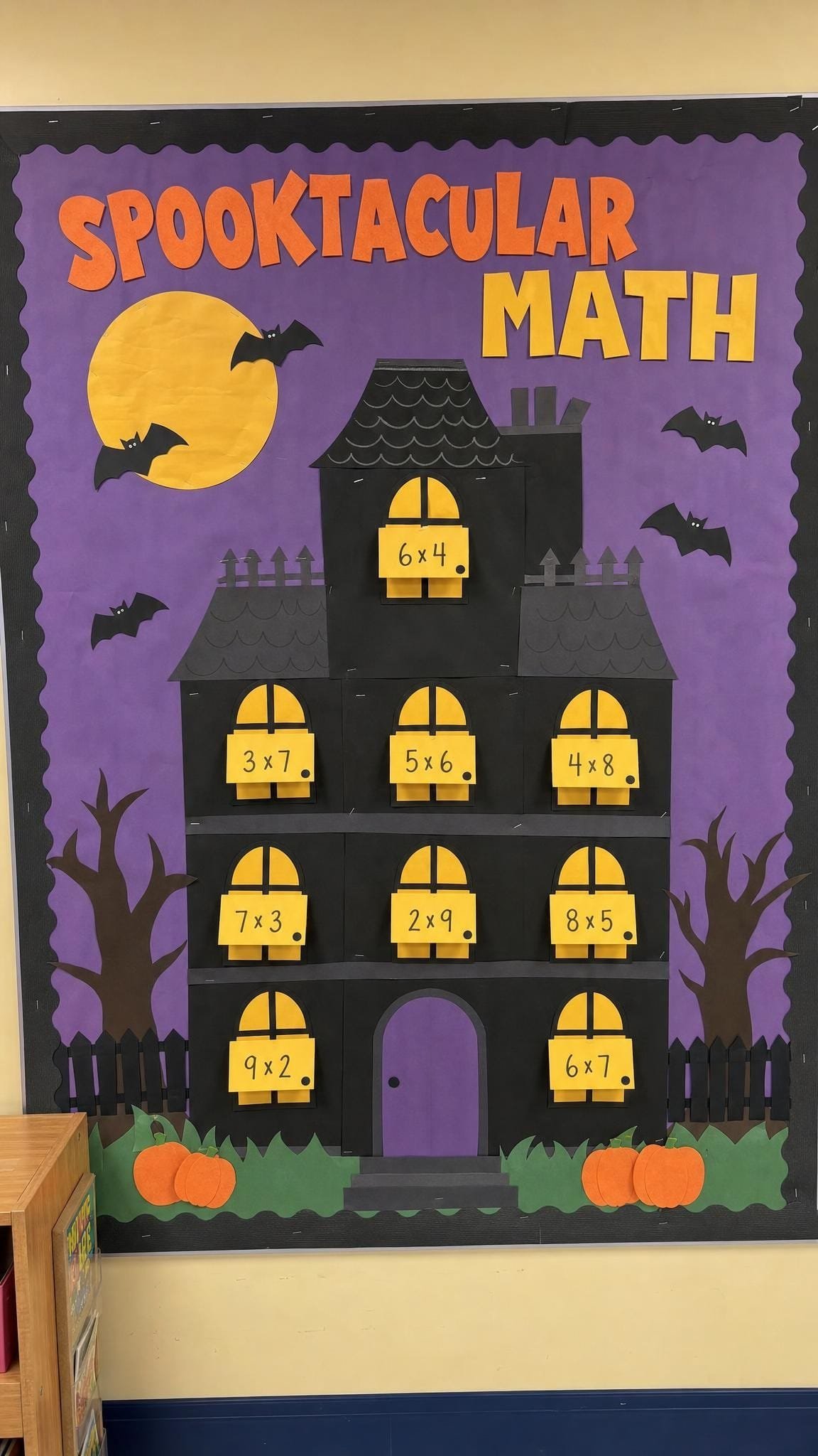 Haunted house bulletin board with lift-the-flap windows showing multiplication facts